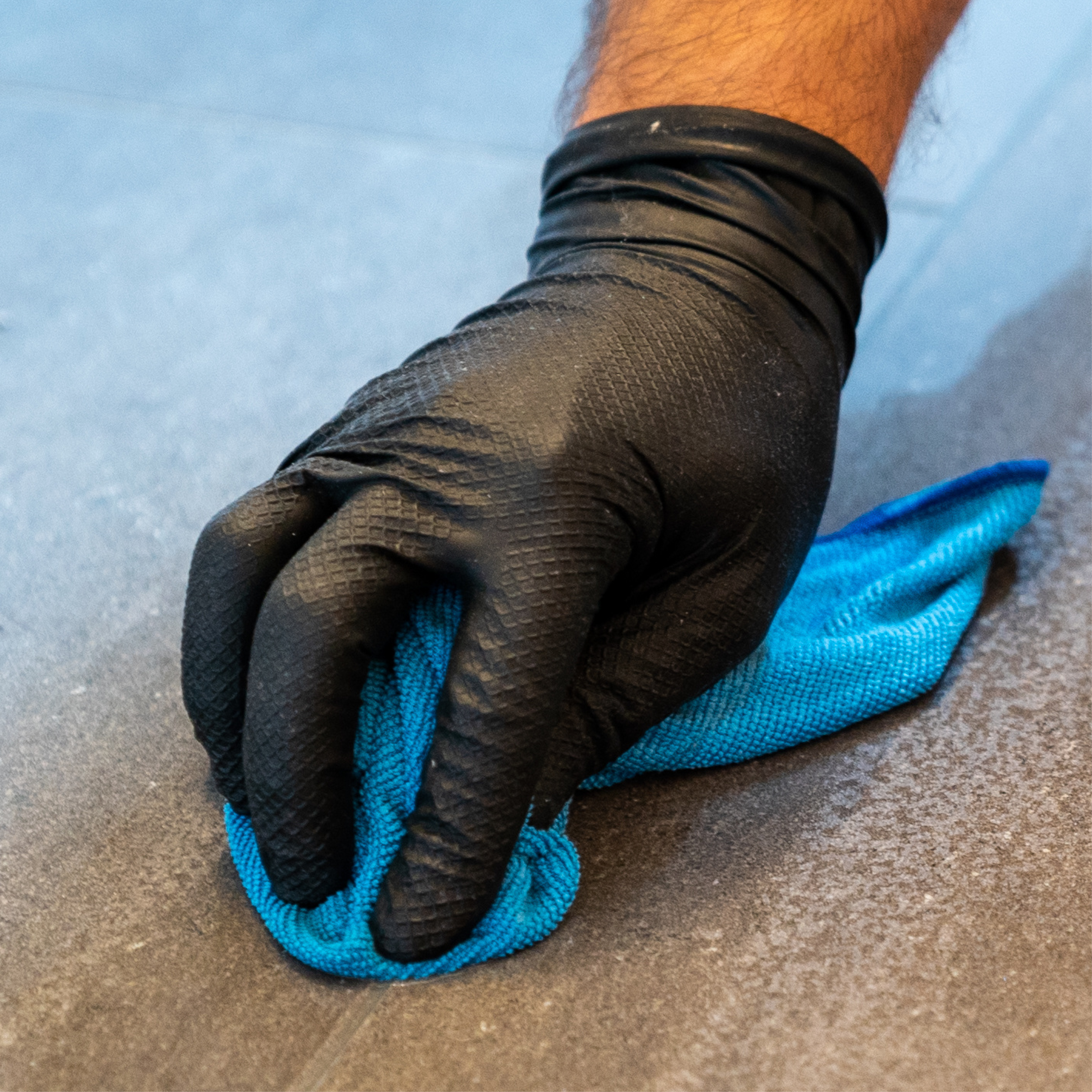 Nitrile gloves Power Grip, powder-free in black with example of use cleaning